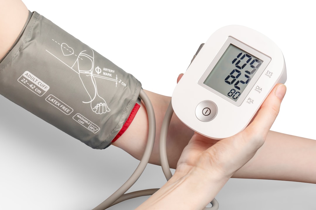 A person measuring their blood pressure at home using a digital monitor, with a calm and focused expression.